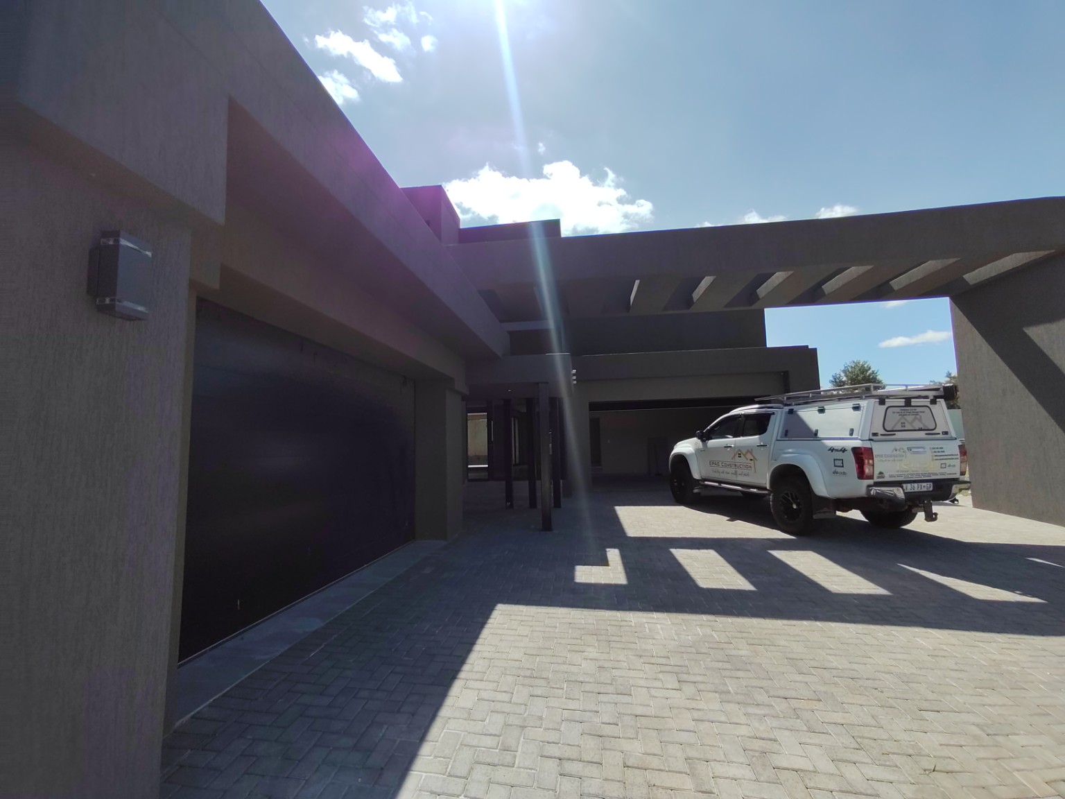 Completed double-volume residential interior with staircase and kitchen